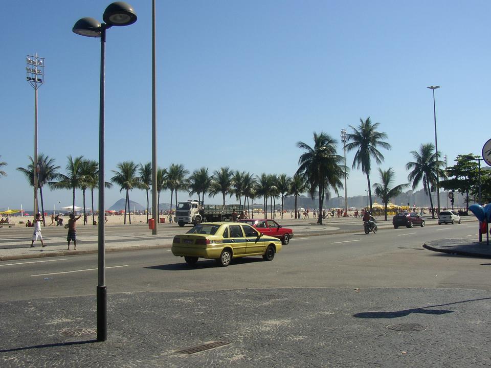 Táxi amarelo cruzando avenida à beira-mar